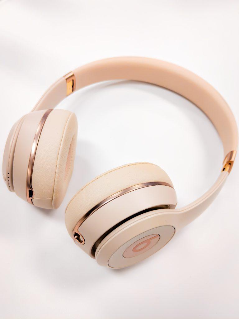 A rendering of the Rose Gold Beats headphones, featuring a sleek and stylish design with a rose gold finish and black accents, padded headband and ear cushions, and advanced noise-cancellation technology. The over-ear headphones can be connected wirelessly to a variety of devices.